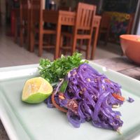 Scoop from the big plate of butterfly pea pad Thai. at Anchan Vegetarian Restaurant in Chiang Mai