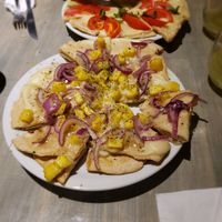 Hawaiian pizza with Napolitano pizza in the background at Cuenco in Mendoza