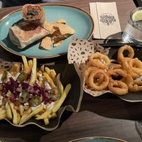 Outlaw burrito (CHF 16.00) with crispy onion rings (CHF 05.00) and vegan loaded fries (CHF 12.00)  at Burrito Bandito in Bern