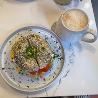 Everything bagel with vegan cream cheese, vegan scrambled egg, vegan bacon bites and tomatoes and a banana bread latte at OH Bagel in Muenster