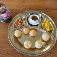 Pani puri as a starter . You have to stuff the hollow balls with the ingredients and the sauce. at Little India in Nijmegen