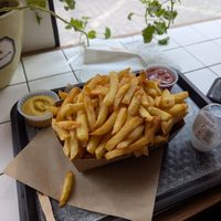 Large fries with mustard and ketchup. at 't Brugsch Friethuys in Bruges