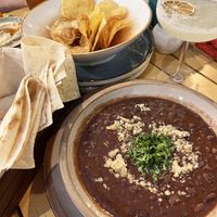 Delicious and hearty vegan red bean soup topped with walnuts and cilantro. A little further away—homemade potato chips and hummus. at Machar 44 in Yerevan