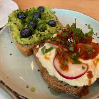 Breakfast toast with smashed avocado-pea-creme and cream cheese with dried tomatos   at Morgentau. in Barcelona