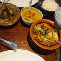 Main courses (mushroom biryani and aubergine) with sides (rice, bread, dal and potatoes) at Trishna in London
