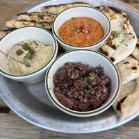Vegan Muhammara, hummus, and black olive tapenade with delicious grilled bread.  at Bar Neon in Toronto