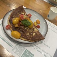 Chickpea pancake stuffed with eggplant and almond “cheese” and topped with fresh tomato  at A Casa di Francesco in Palermo