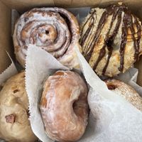 Cinnamon roll, Samoa donut, maple bacon donut (w/ coconut bacon), classic glazed, and strawberry jelly filled  at Sweet Theory Baking Co. in Jacksonville