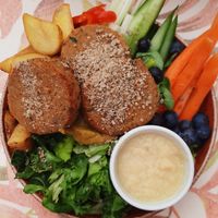 Buddha bowl with veggie patties, potatoes, different kinds of lettuce, selery, cucumber, carrots, bell pepper, blueberries, olives, vinaigrette dressing, honey mustard sauce at Carmen in Miedzyzdroje