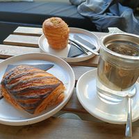 A pain au chocolate, a pistachio cruffin and genmaicha tea. at Crave Coffee & Bakery in Rotterdam