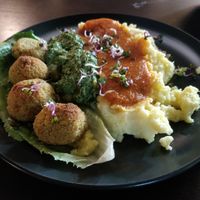 Main course: smashed potatoes and couscous "meat" balls with tomato sauce and pesto at Nom Nom in Bucharest