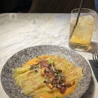 Steamed leeks on harissa cream topped with a green apple vinaigrette and roasted cashews.  at La Huerta Funky Castizo in Madrid