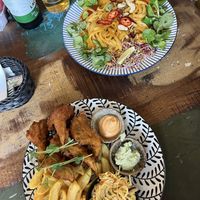 Top plate: pad thai with tofu and mango, bottom plate: fried oyster mushrooms with salad and fries .  at Vega in Wroclaw