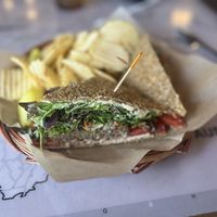 Athena’s Gift- Raw, gluten-free vegan sausage topped with cashew cheeze spread, spring mix, olive salad, and tomatoes. Served with chips and a pickle spear    at European Street in Jacksonville