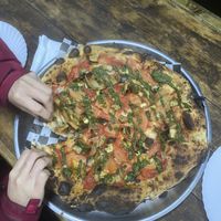 Vegan #1 pizza, family size, with hungry hands  at La Cova Pizzería in Pucon