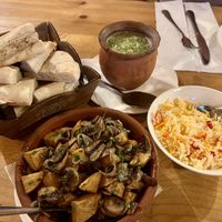 Rice, beans in a clay pot, mushrooms with potatoes, and Georgian bread  at Restaurant Cozy Corner Kazbegi  in Stepantsminda
