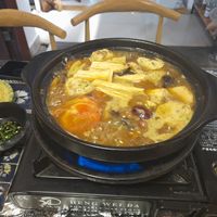 Cooking vegetables and tofu in the hotpot broth at Yún Shān Zhī Jùn 雲山之菌 in Dali