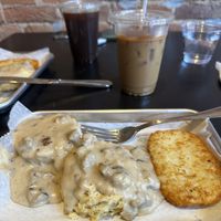 Biscuits and gravy with a hash brown patty. The coffees in the background have coffee ice cubes!  at Brunch Box in Springfield