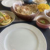 Vegetable biriyani, accompanying sauce, tandoori roti and Kathmandu aloo. Pilau rice in the background   at Buddha's Eye Indian Restaurant in Mallorca