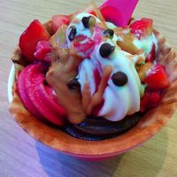 Fudgicle, pomegranate raspberry, and Oatly Vanilla flavors with peanut butter sauce, raspberry sauce, carob chips, strawberries in a waffle cup at 16 Handles  in Naples