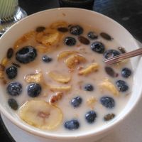Granola bowl with almond drink, dried banana slices and blueberries at A Little Lost in Munich