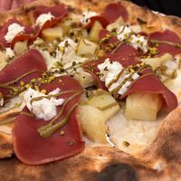 Pizza with baked potatoes, fake speck, pistacchio cream and stracciatella cheese  at Bottega di Rosaria in Siena