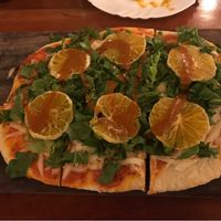 Vegan pizza with tangerines at La Hoja Verde in Tulum