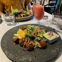 Tofu Bällchen auf Salat, Guavensaft gespritzt. Gegenüber: Tempeh auf Quinoa und Gemüse  at Cool Run Inn in Innsbruck