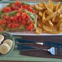 Avocado and tomatoes on bread with fries and fruit at Barmezzo - YellowSquare Firenze in Florence