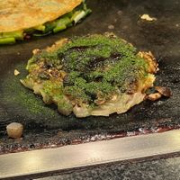 Vegetarian Okonomiyaki without egg. Mushroom and konjac inside. Sauce, aonori seaweed and mustard on top.   at Okonomiyaki Mizuno in Osaka