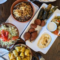 Mujadara; vegan platter (vine leaves, cabbage rolls, kibbeh, falafel, hummus); potatoes with kizbara. at Shamiat Authentic Syrian Restaurant in Northcote