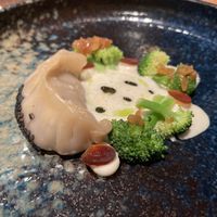 Dumpling with seitan and mushrooms, miso foam, soy sauce fermented garlic, vegan mayonnaise, herb oil and broccoli  at Wolfs Junge in Hamburg
