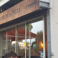 There are tables outside and inside at L'Atelier de la Pizza in La Grande-motte