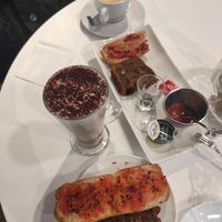 Café con leche, capuchino (taza larga), tostada con tomate y banana bread at Vibracafe in Valencia