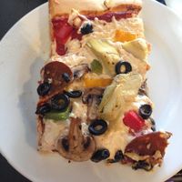 Pizza with vegan pepperoni, fresh garlic, olives, artichoke hearts, onions, bell peppers, and mushrooms at Timeless Coffee Roasters and Bakery in Oakland