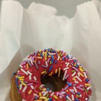 Donut with rainbow sprinkles at Kupfert & Kim - Financial District in Toronto