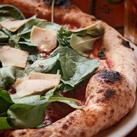 VEgan pizza STAR : Tomato sauce, plant-based mozzarella, plant-based sausage, gondino, garlic oil, fresh mint, baby spinach at Martha Pizze Amore in Paris