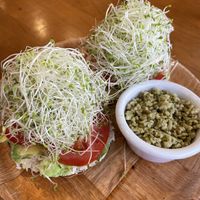 Macadamia but garlic spread on a bagel with tomato, bean sprouts, and tabbouleh at Sweet Cane Cafe in Hilo