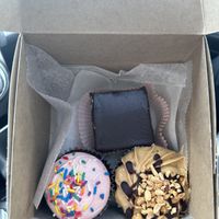 Top is mint brownie, bottom left chocolate cupcake with strawberry frosting, bottom right peanut butter chocolate cupcake  at Petunia's Pies and Pastries in Portland