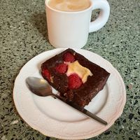 Raspberry brownie and latte. at Korzenie Kuchnia Roślinna  in Szczecin