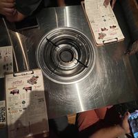 Empty table where all the food is kept and you cook/bbq them. Tight space for food and peoplee  at Daldongnae - Ottawa Somerset in Ottawa