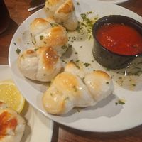 Garlic knots arrived in a pool of butter, slightly raw inside at Pasta Grill Mansfield in Hackettstown