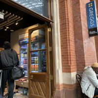 Upstairs in St. Pancreas Station, two tables by entrance to shop  at Greggs - St Pancras Station in North West London