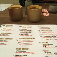Back side of the vegan menu with pickled cucumber, konjac sashimi and sake in the back  at Hokusai in Fukuoka