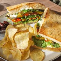 Smashed avocado, spinach, roast veg with vegan mayo on toasted focaccia with olives and crisps. at Norse Bakehouse in Lairg