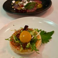 Caramelized Onion Tart with yellow tomato egg yolk, frisée and mushroom pancetta. at Crossroads Kitchen in Los Angeles