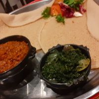 "Yemsir wot" - red lentil stew with red peppers, ginger and garlic, spinach stew "gomen" and injera. Delicious! at Lucy Etiopiska Restaurang in Umea