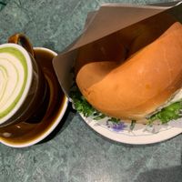 Photo of bagel filled with mozzarella pesto and matcha latte with oat milk. at Round Kamppi Café in Helsinki