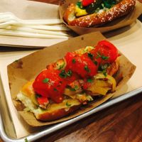 vegan dog on a potato roll with pico de gallo, grilled onions, fresh tomato, guac on a potato bun at Linx in Orange