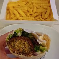 Kebab vegano con falafel, guacamole, hummus, tomate, cebolla roja y lechuga, acompañado de patatas fritas. at The Real Food Co. in Malaga